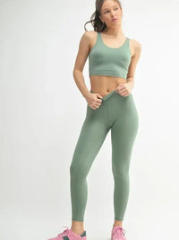 Model wearing MONO B activewear U-back tank top paired with matching leggings in a soft green color.