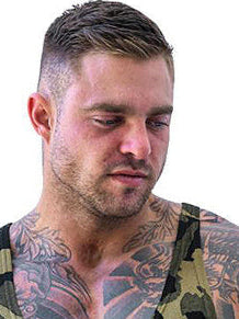 Man wearing a camouflage tank top with tattoos on his arms against a white background
