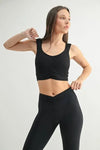Woman wearing a stylish MONO B ruched active tank top paired with black leggings, showcasing a flattering silhouette.